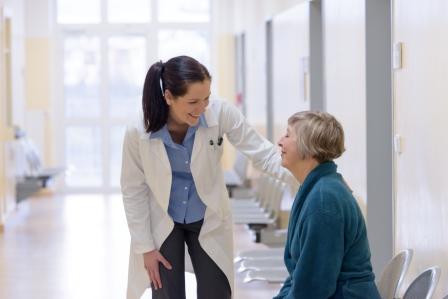 Smiling female doctor talking to senior patient in hospital